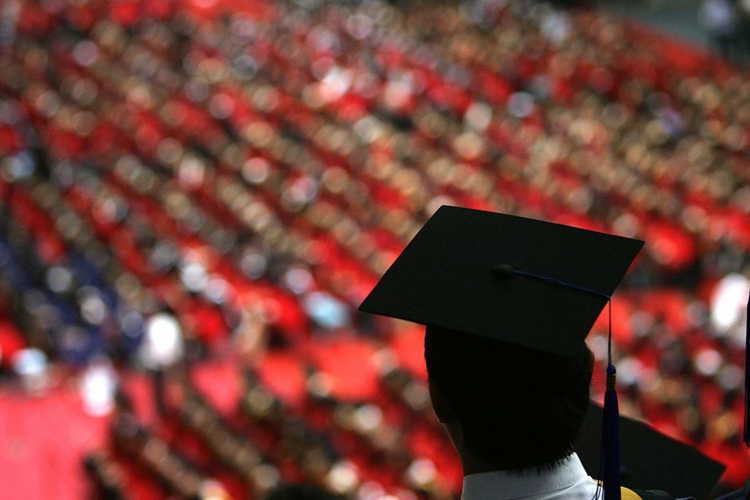 2007年7月18日,清华大学举行毕业典礼,一名戴着毕业帽的学生背对镜头,以俯视角度盯着下方多名出席典礼者。