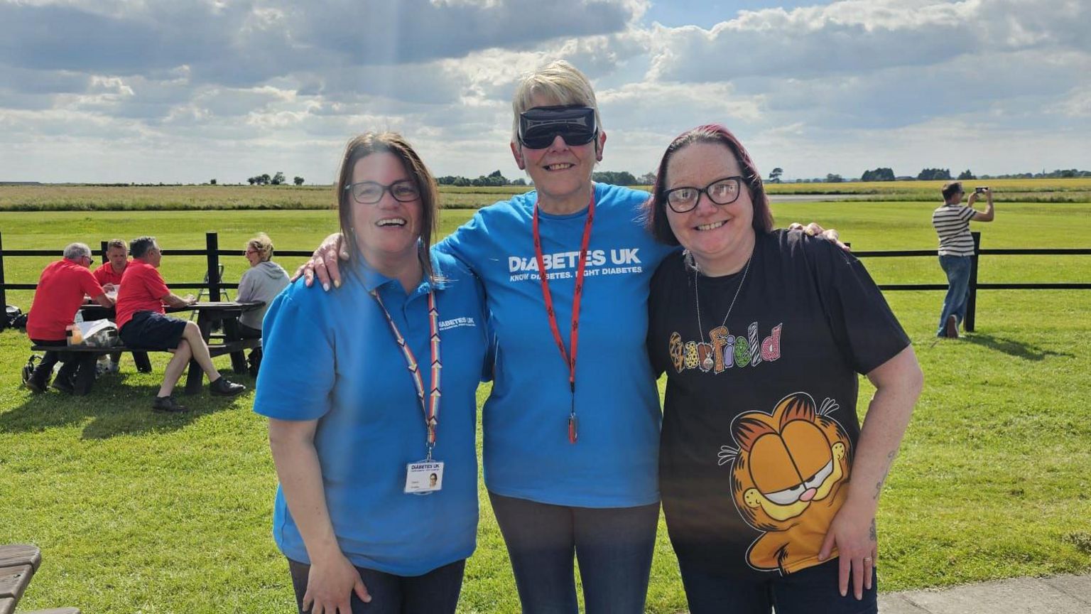 Three women smiling at the airfield where Joy's flight took off