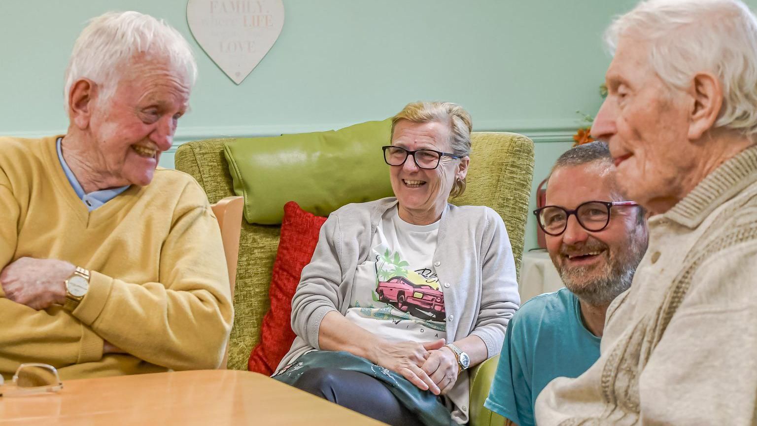 Care home residents sitting next to each other laughing