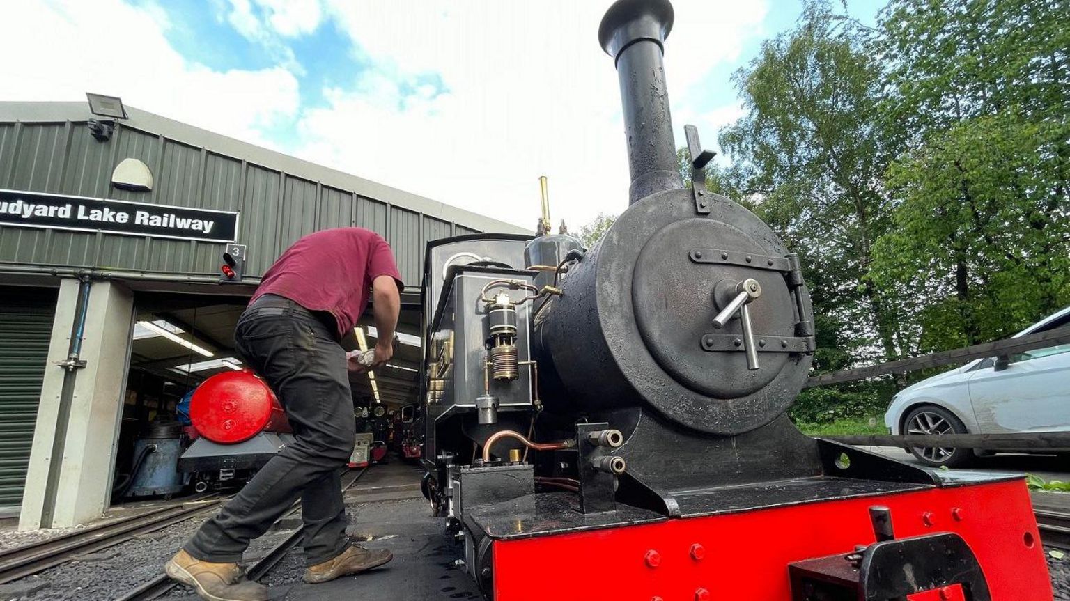A man next to a steam engine