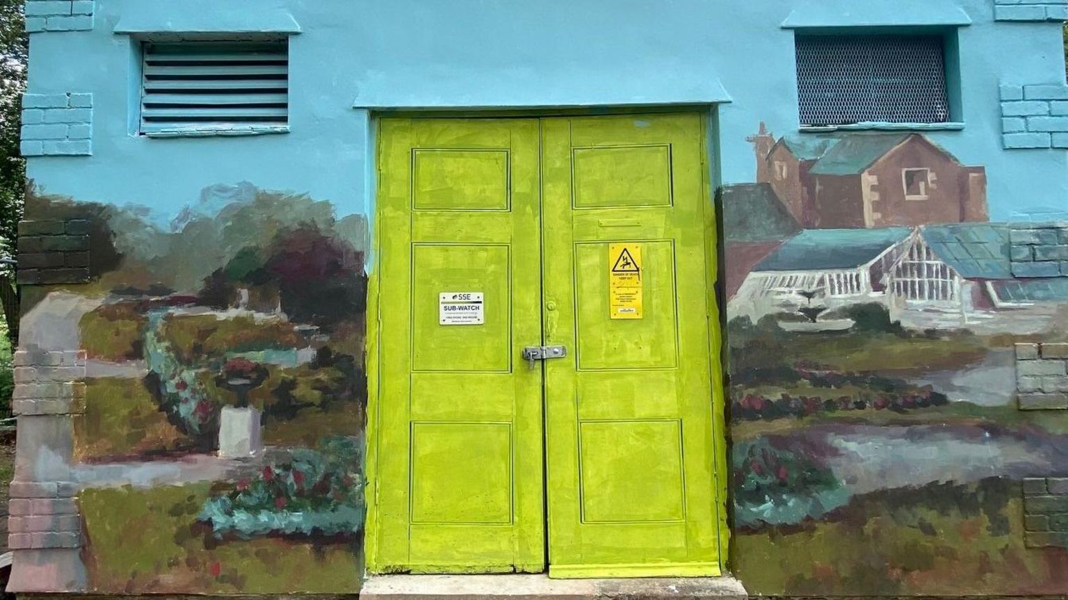One side of the mural around a bright green doorway