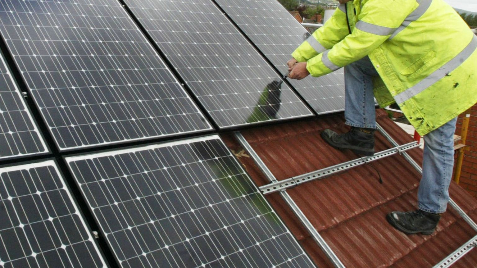 Man installs solar panels on roof