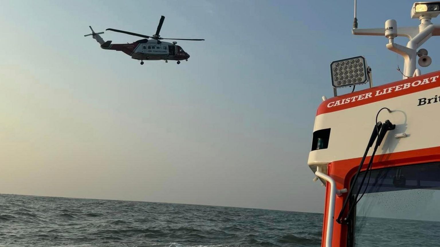 A photo taken from Caister Lifeboat of a Coastguard helicopter hovering above the sea