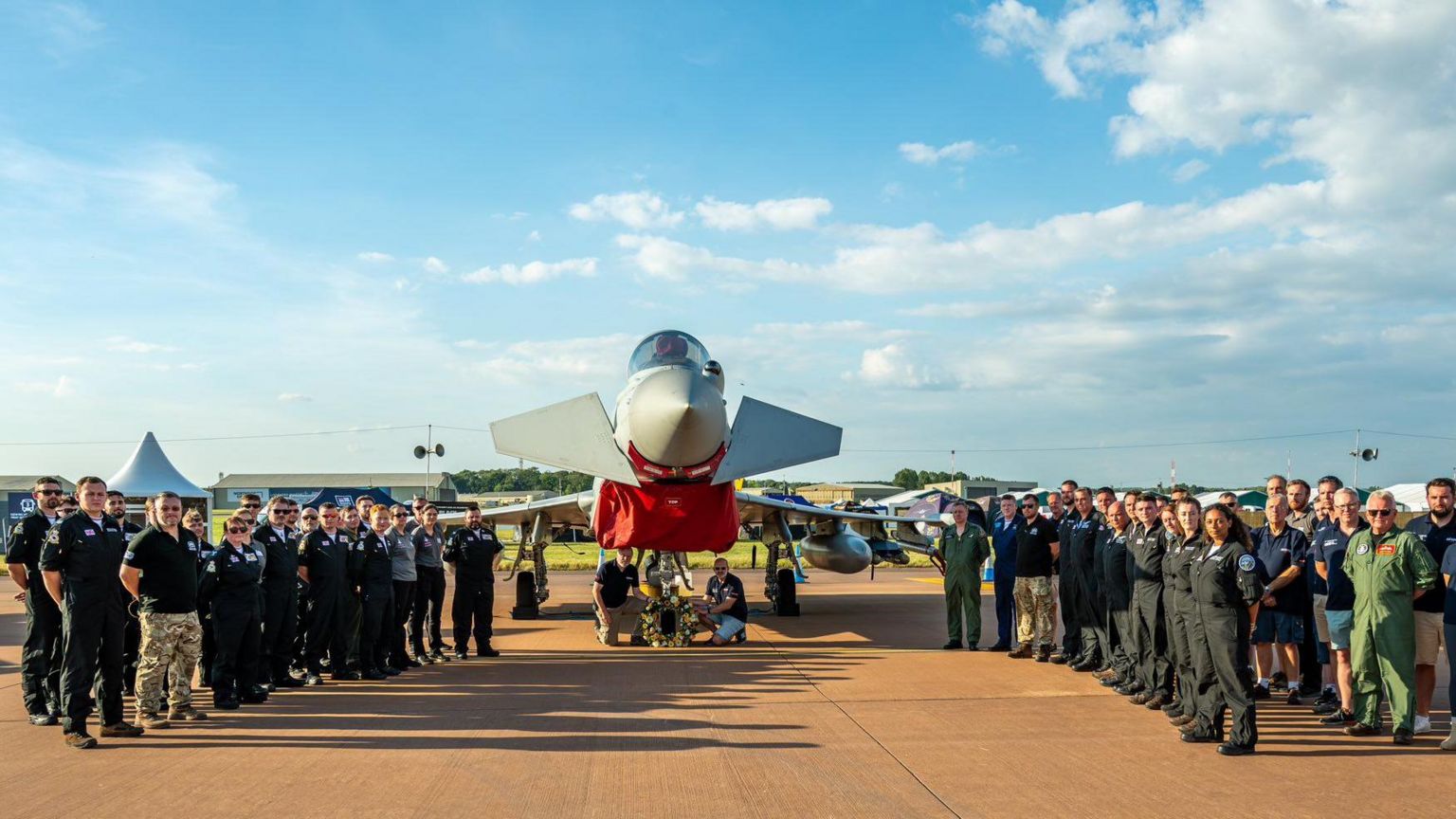 A wreath to Mark Long in front of a Typhoon modern-day fighter, flanked by hoards of RAF service personnel and a  wreath was laid at the Royal International Air Tattoo