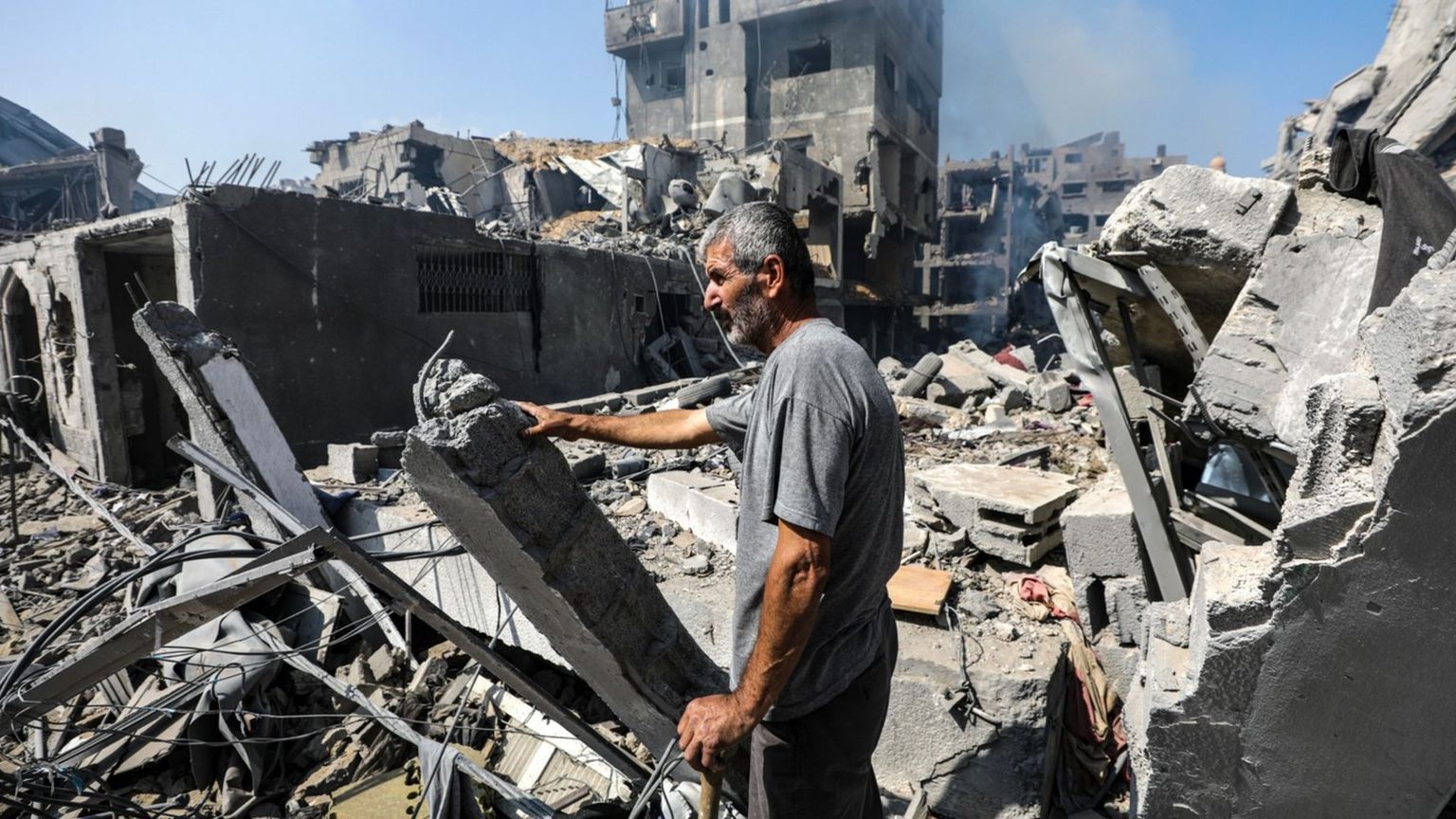 A resident of Gaza City's Rimal neighbourhood inspects the damage after a night of Israeli air strikes (10 October 2023)