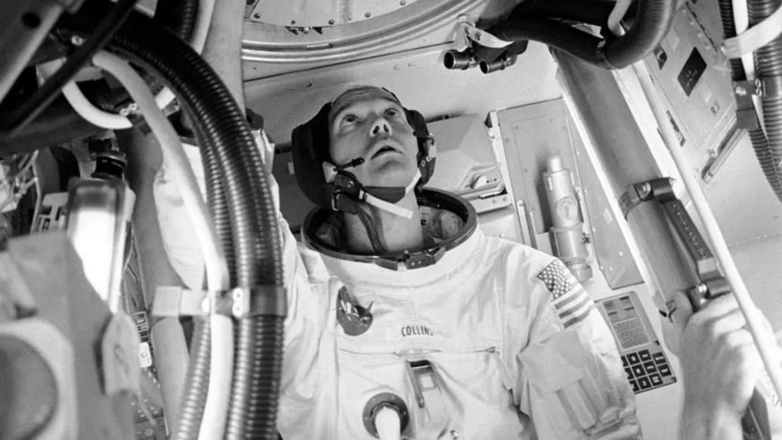 NASA Astronaut Michael Collins looks up towards a portal inside the Apollo 11 module