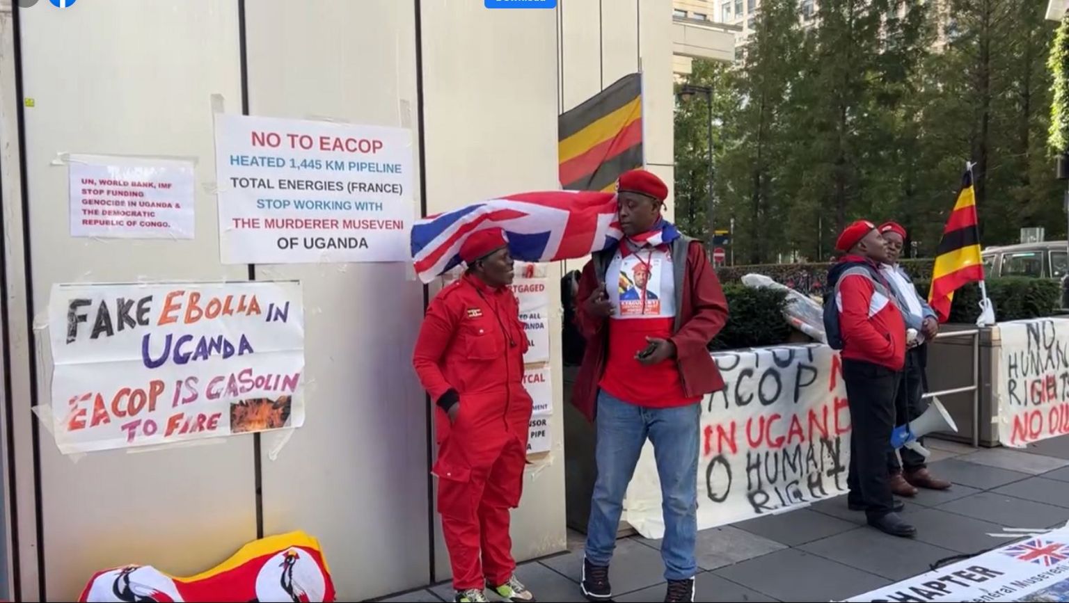 Ugandans at a protest in London with a banner with a message claiming the outbreak is not real