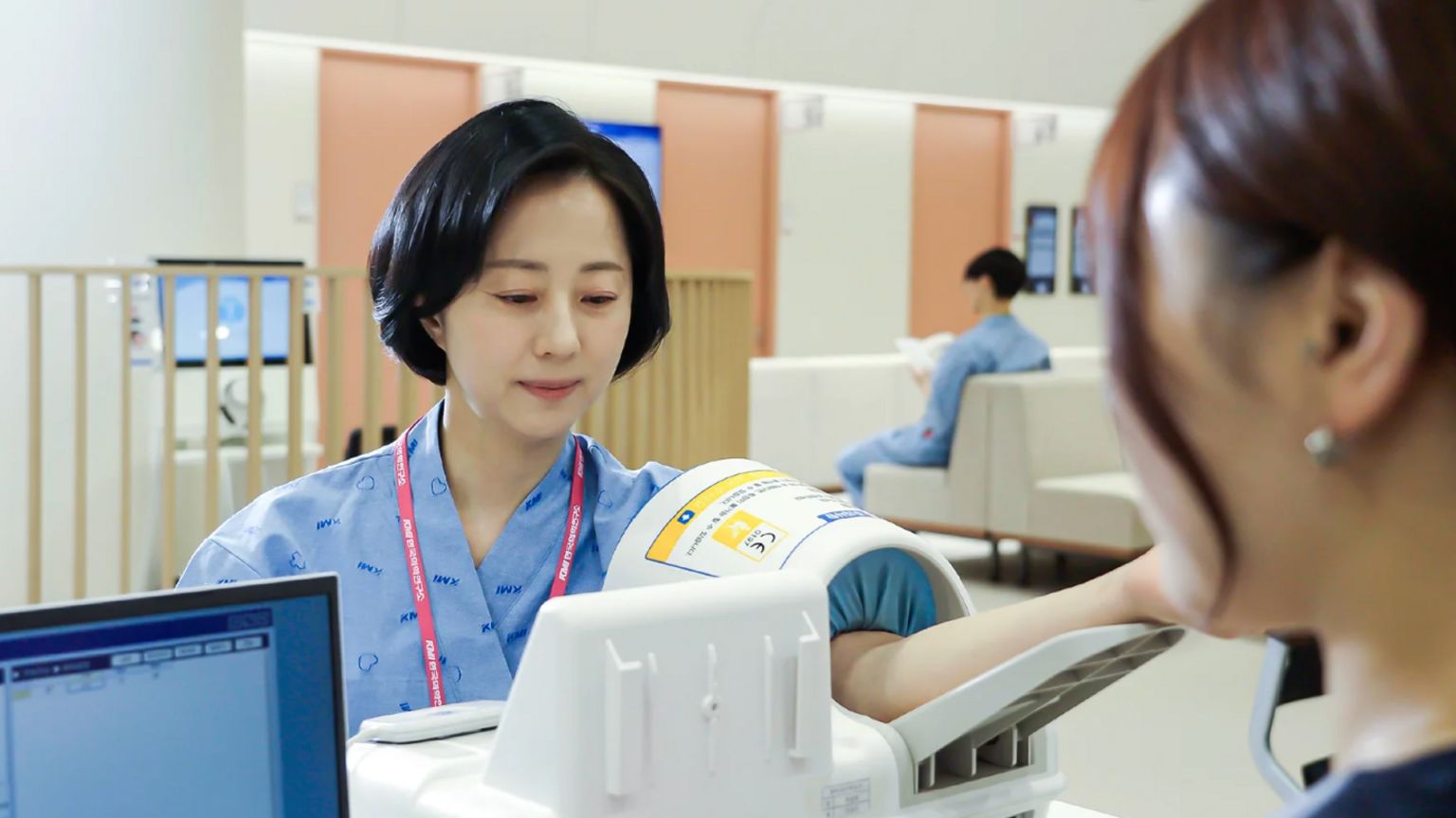诊所内一名女士正用血压机测量血压