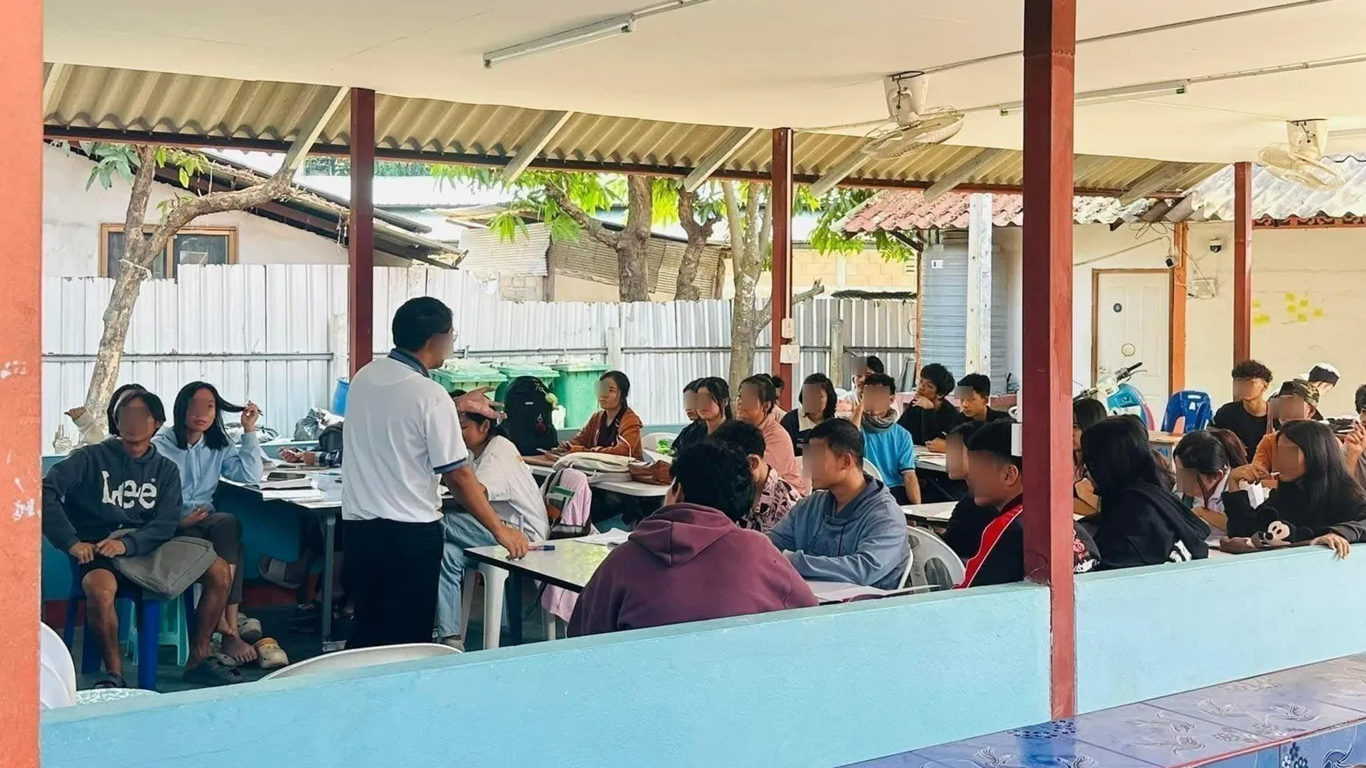 Supplied by student Dozens of students sitting in a classroom, while a man stands at the front