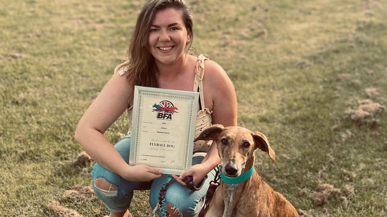 Nadiyah Storey with her rescue dog and a certificate 