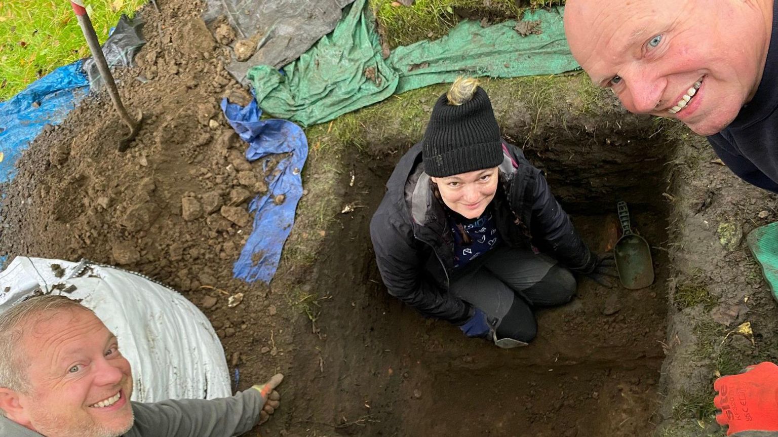 Three people in the dig site 