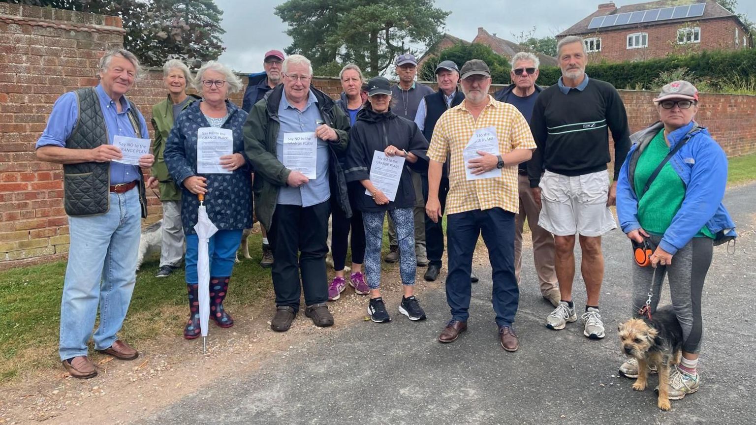 Group of men and women holding posters that oppose plans for Shelsley Grange