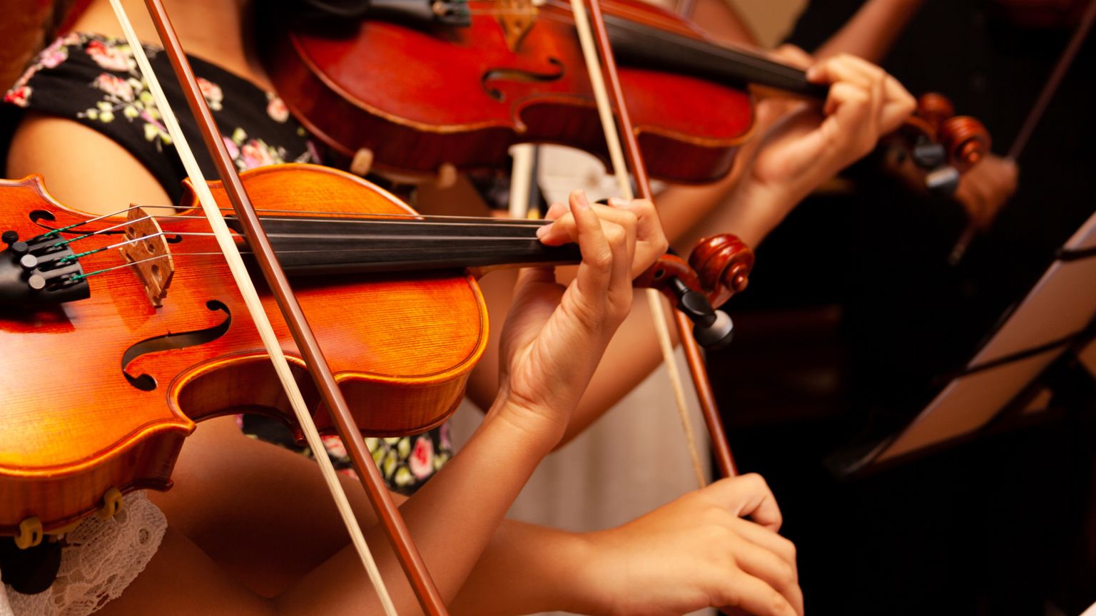 Children playing violins in a youth orchestra