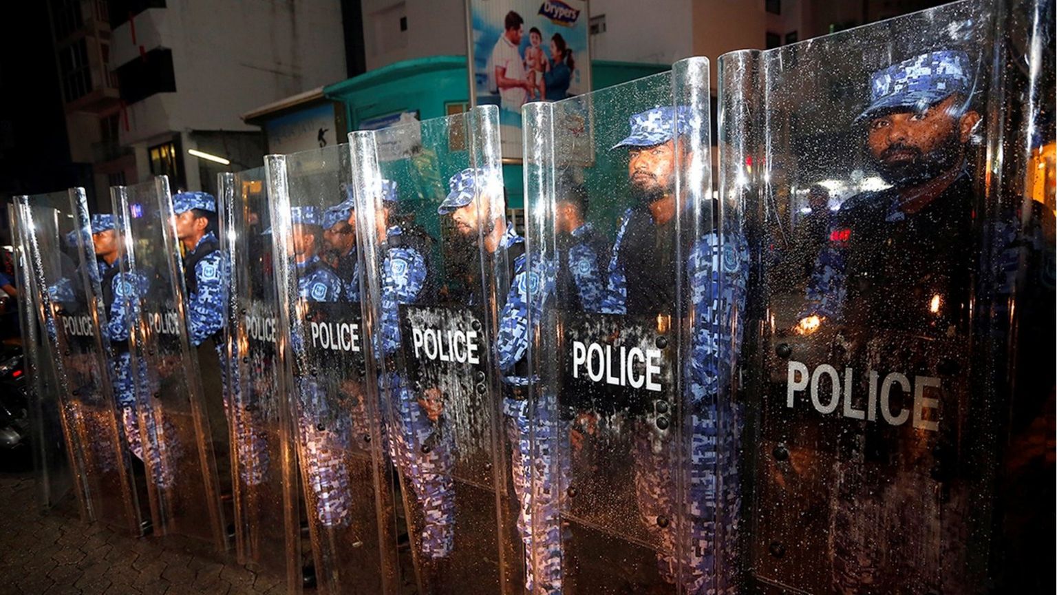Maldivian police stand guard on a main street during a protest by opposition supporters against the government"s delay in releasing their jailed leaders,