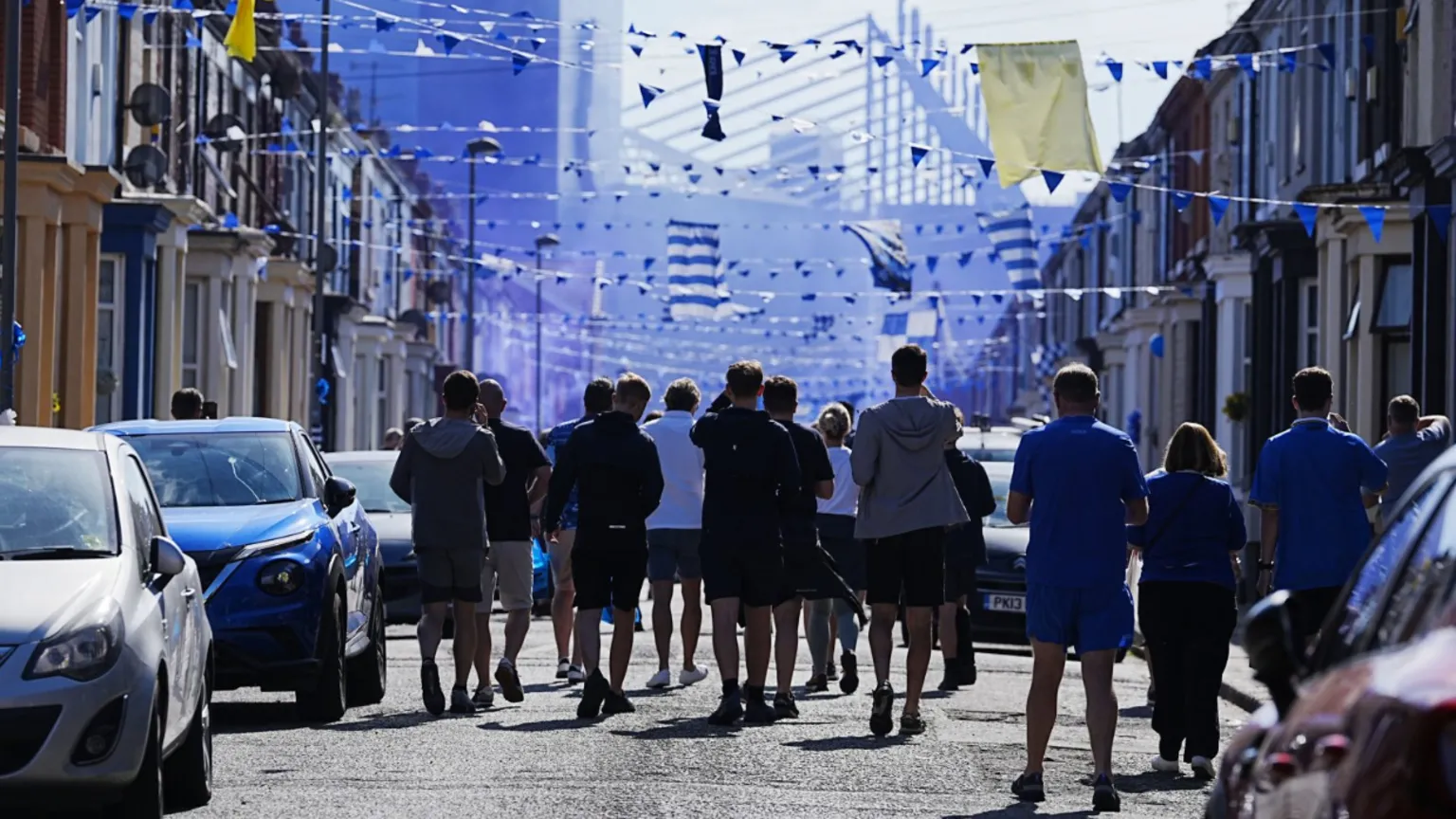 PA Media Silhouetted fans take their usual walk through city streets to the ground, pictured in the background