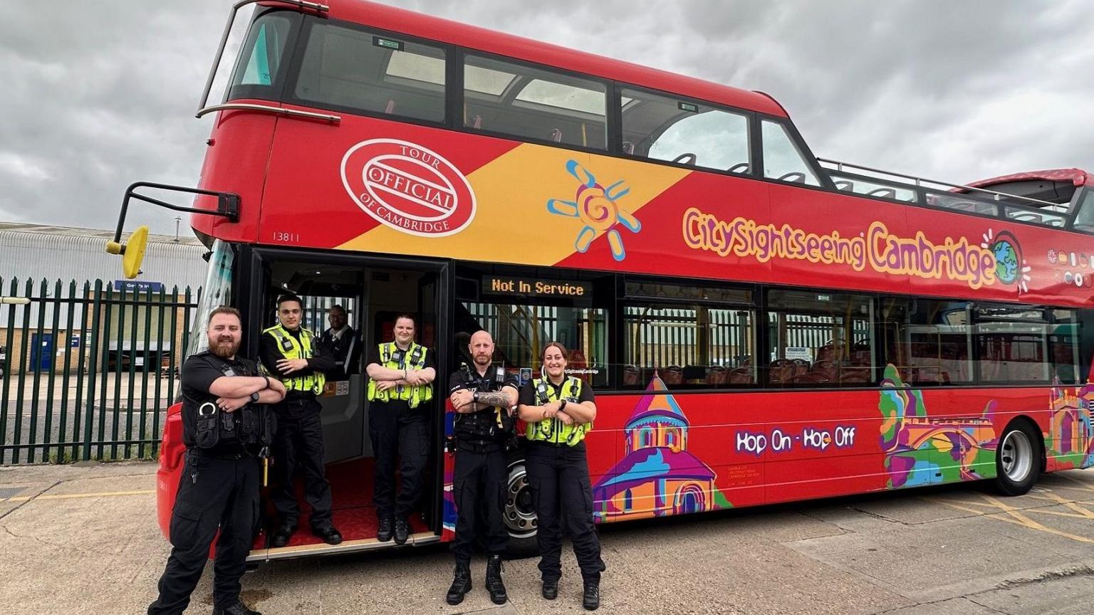 Police officers standing in front of a bus with their arms crossed