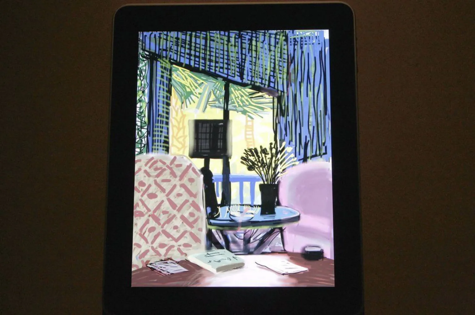 Getty Images David Hockney artwork on an iPad. The painting is of a room with blue walls and red chairs.  It is a still life.