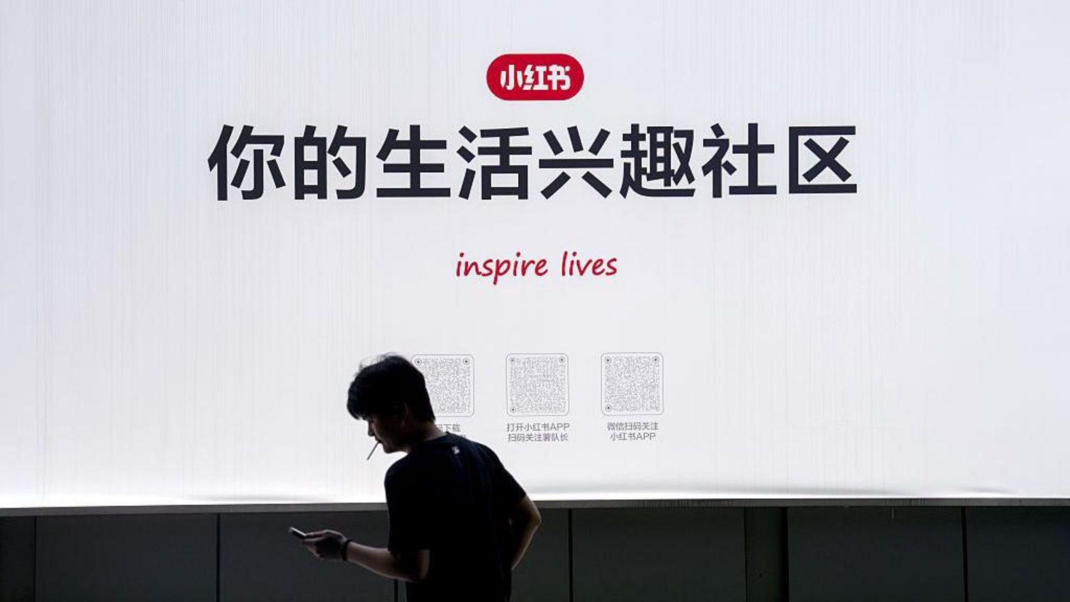 2025年9月15日，小红书在上海总部的标示牌，写有“你的生活兴趣社区”的字眼，一名男子在标示牌前抽烟。