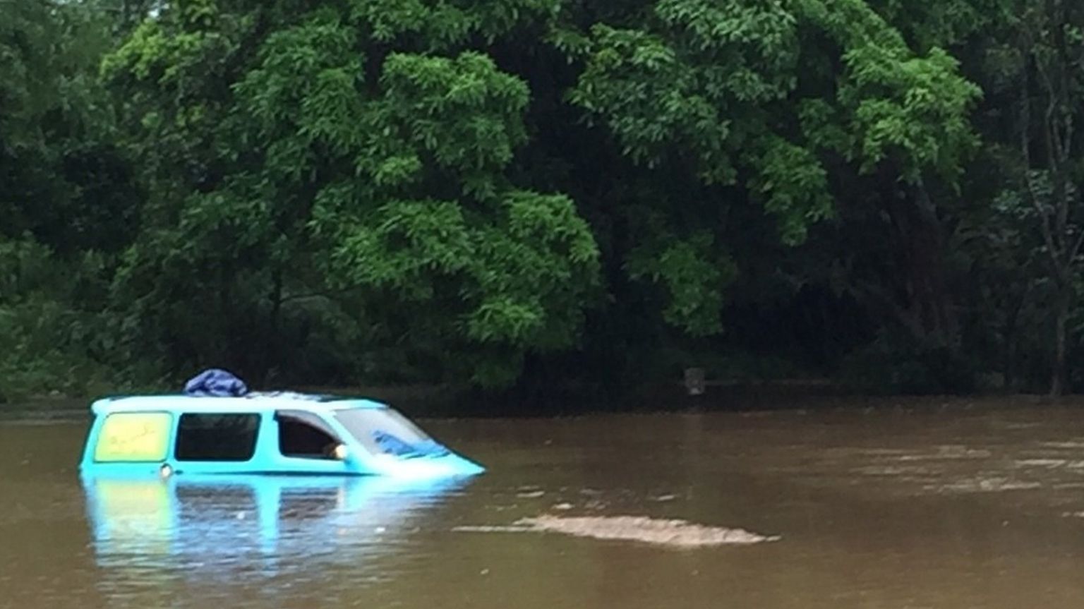 A half-submerged van in a flooded river in Australia