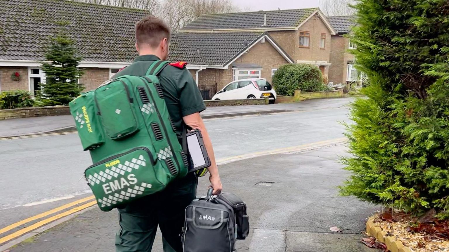 Paramedic carries equipment in street