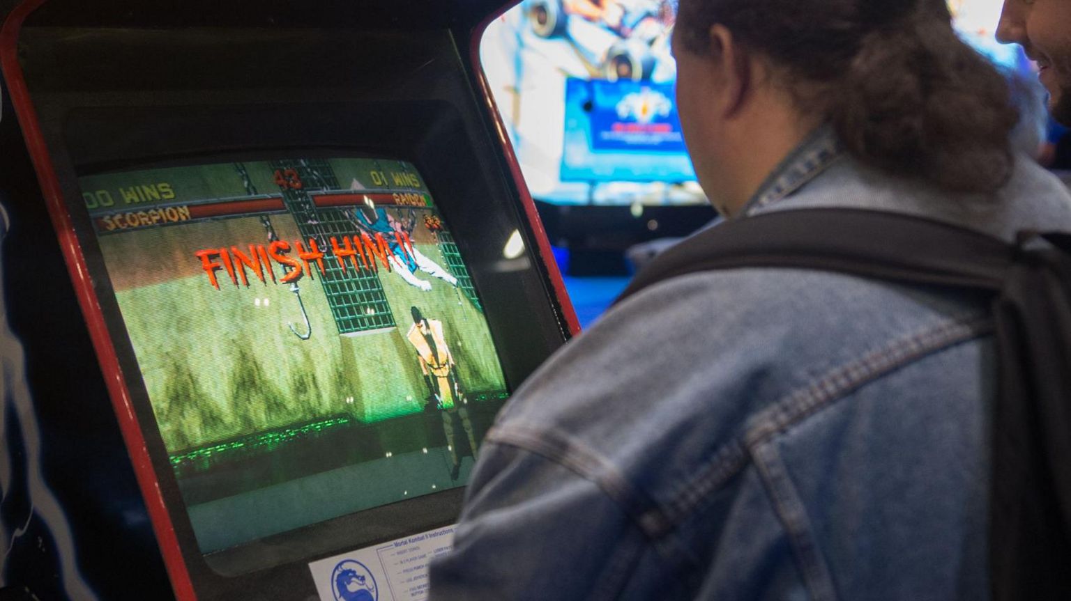 Gamer plays Mortal Kombat on an arcade machine