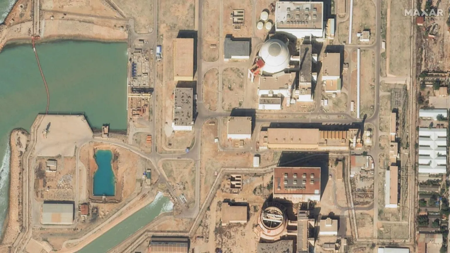 Aerial view of the Bushehr nuclear power plant in Iran, surrounded by desert terrain.