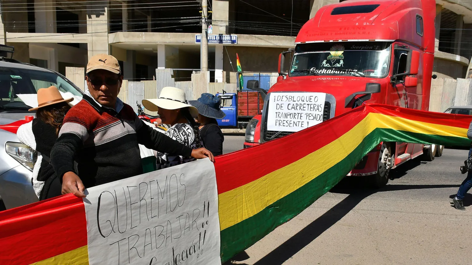 EPA protesters hold a flag and sign next to a road block