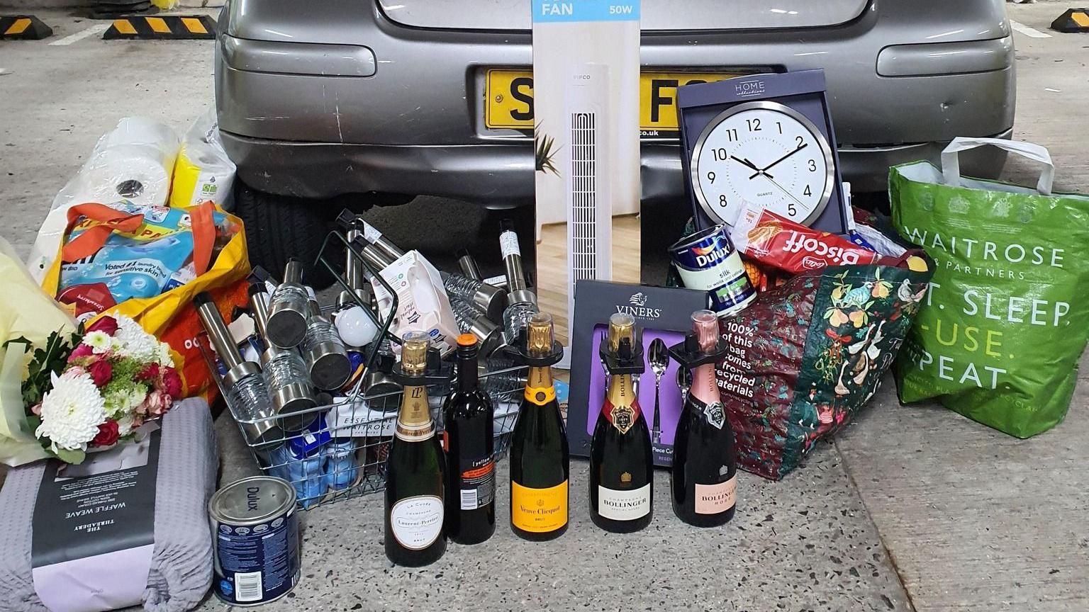 Flowers, paint and sparling wine are all among the items shown next to the car