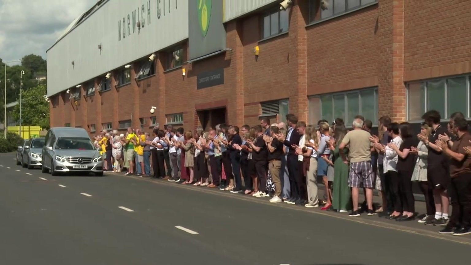 Fans outside Carrow Road applauding the funeral cortege