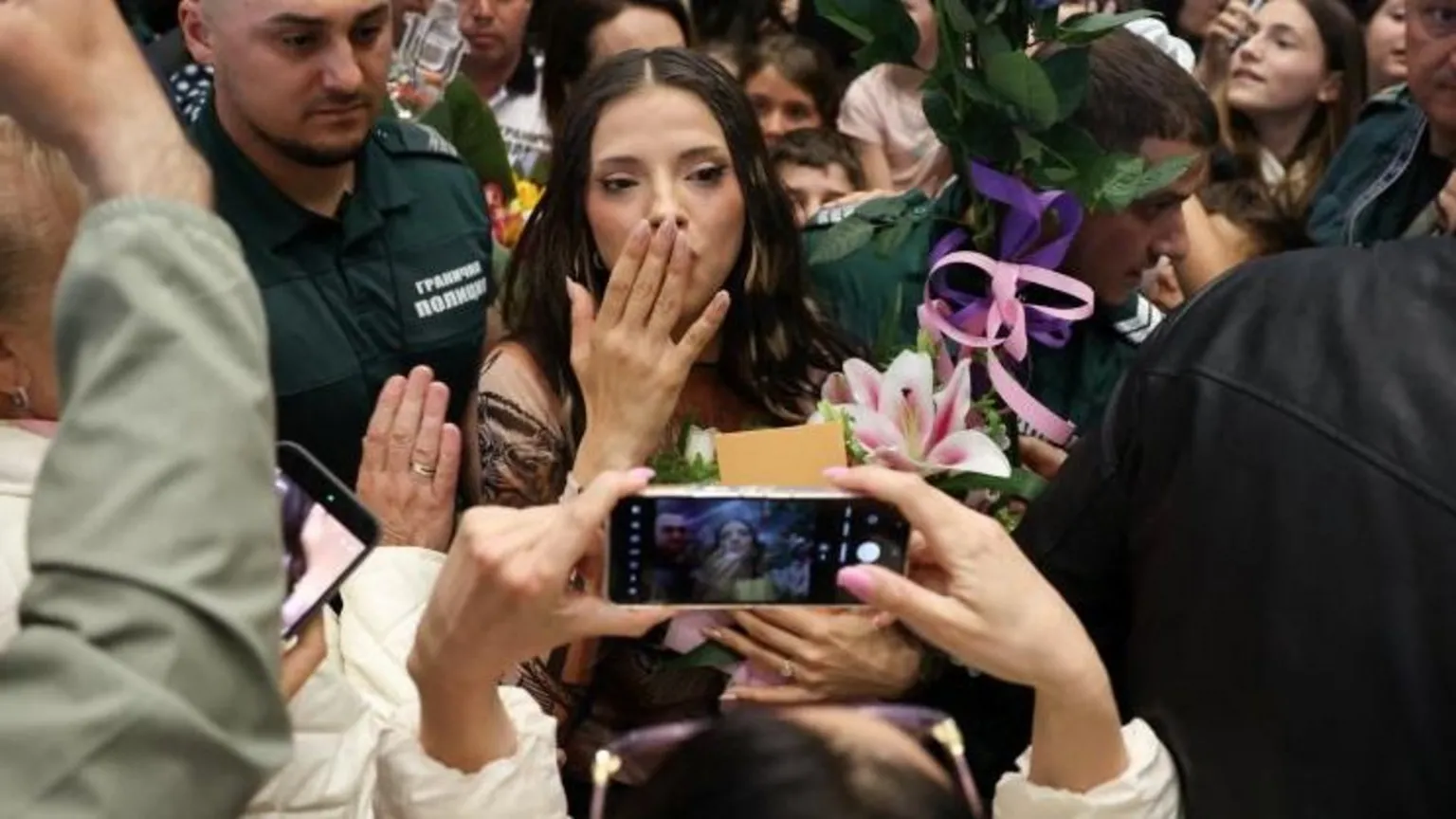 Dara blows a kiss to fans in a busy Sofia airport