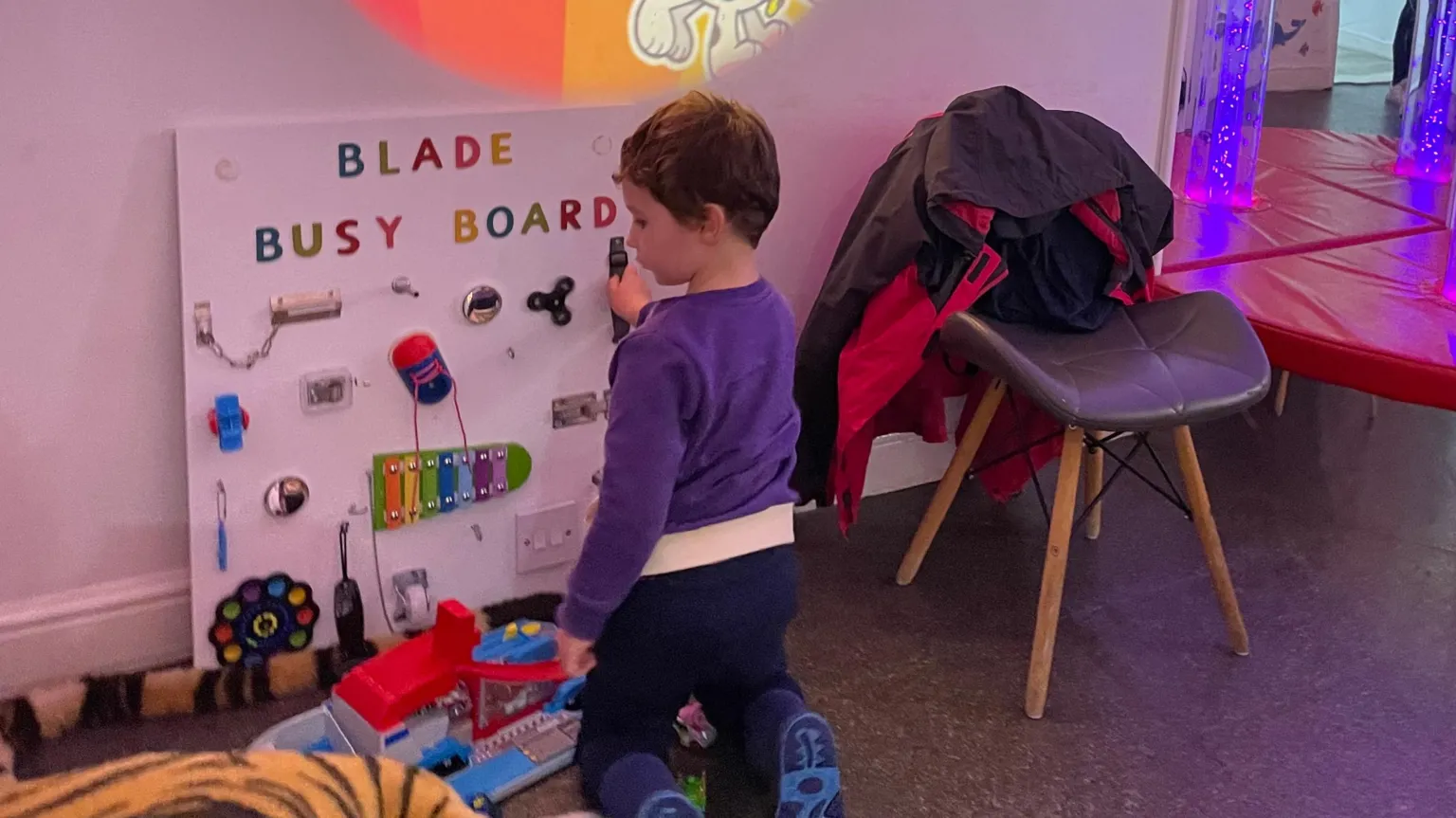 Supplied A young boy playing with a sensory board.