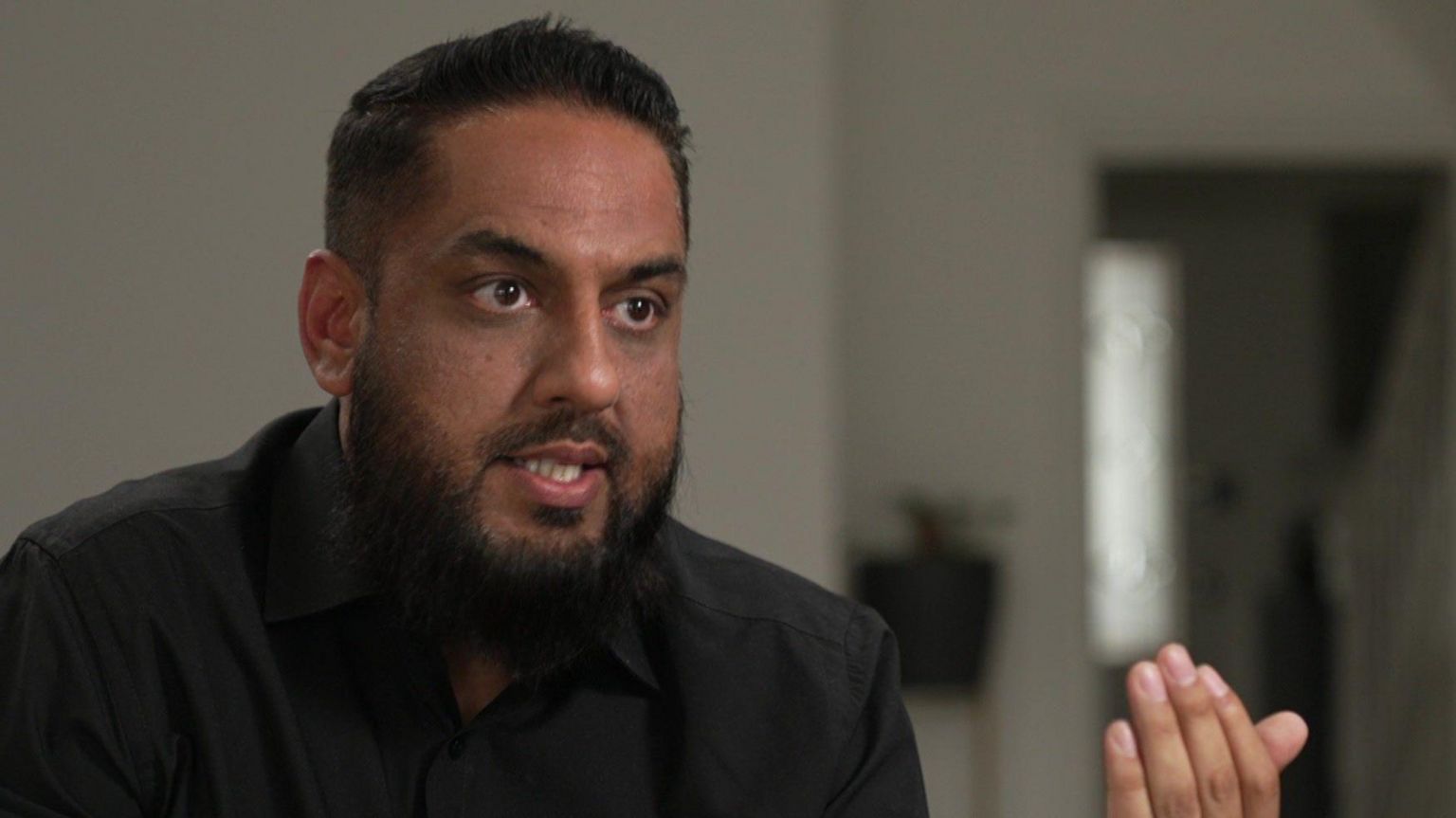 Man in black shirt with dark beard