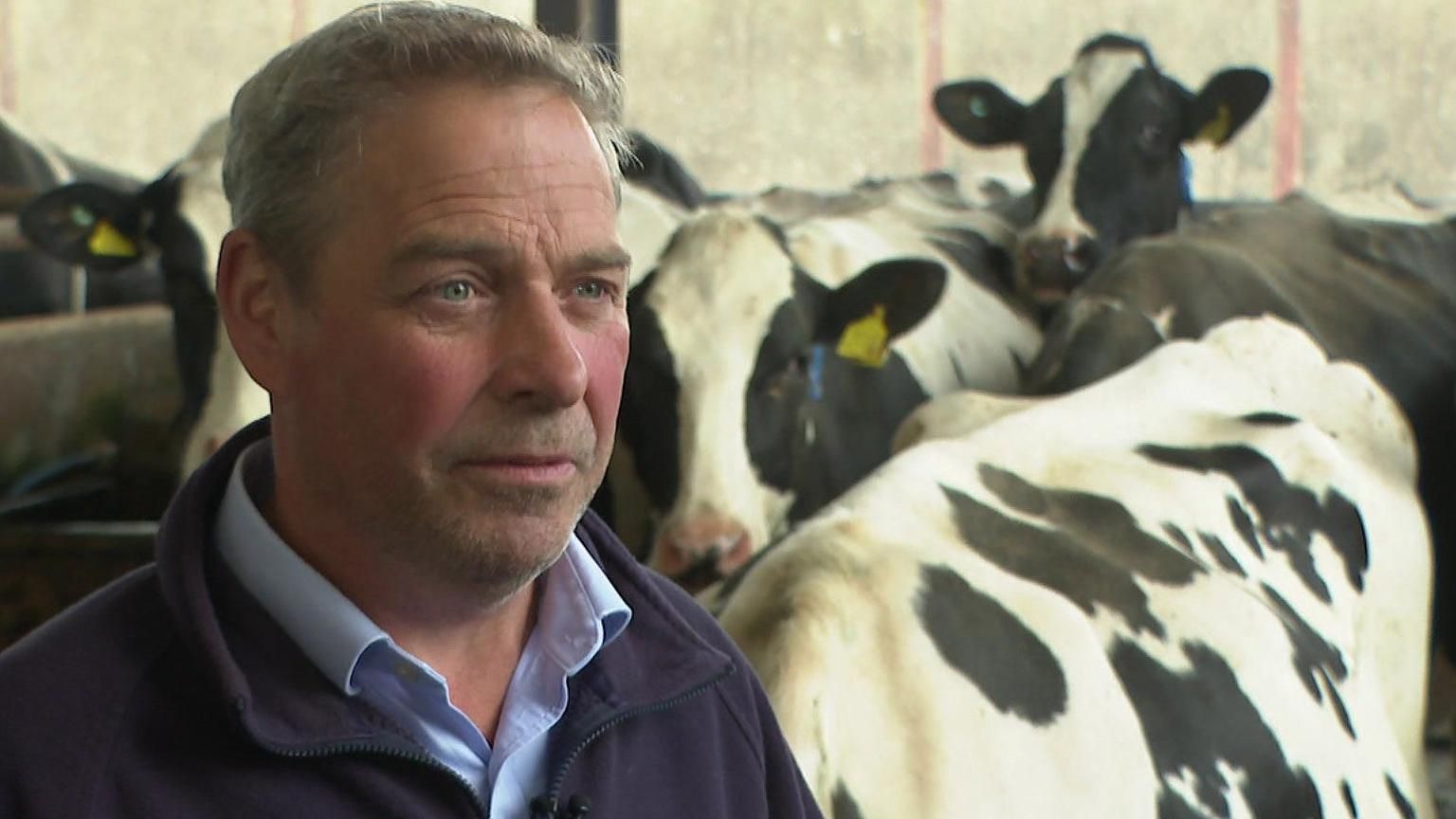 Richard Blackburn wearing a NFU jumper on his dairy farm with some of his cows