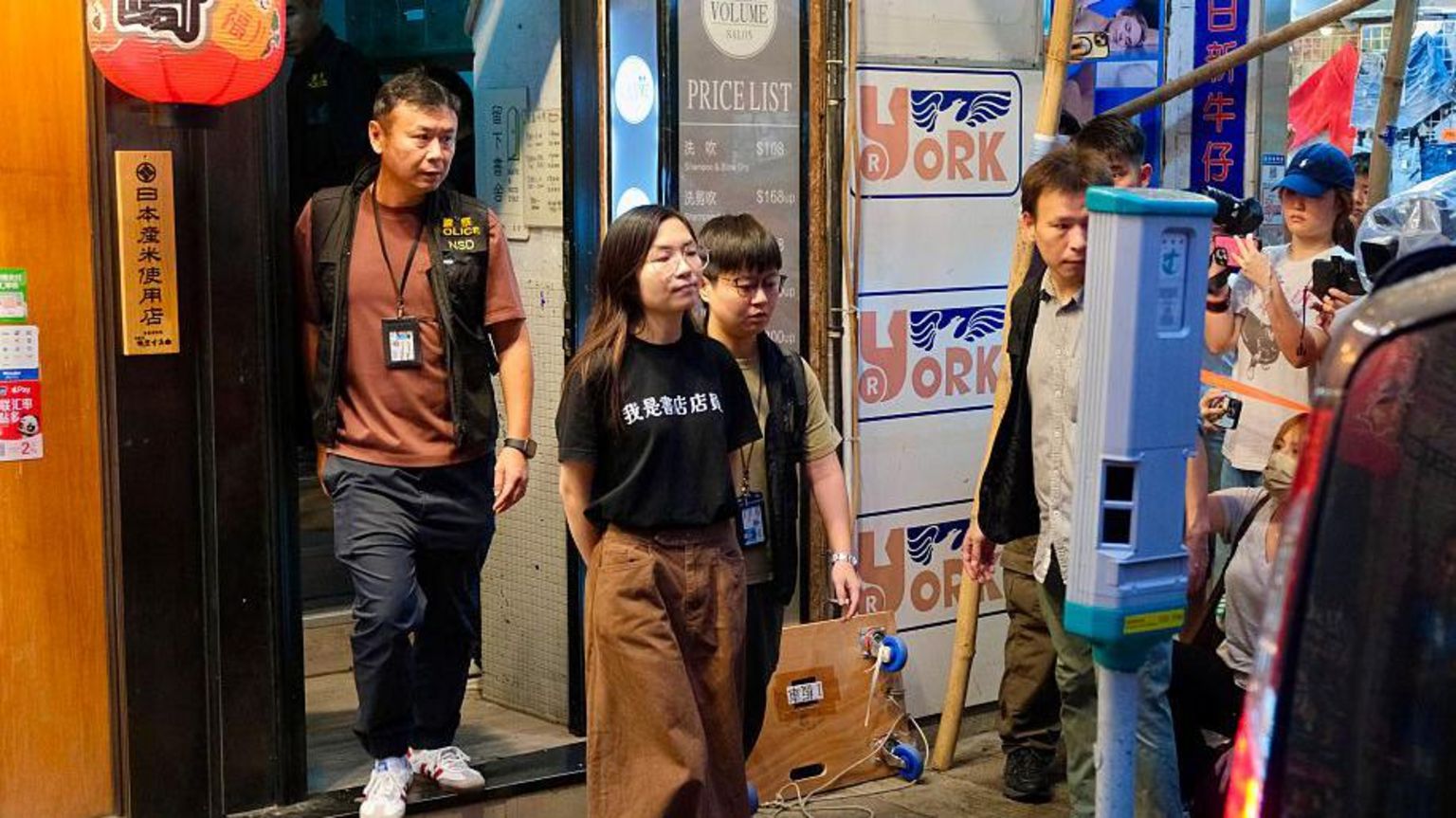 2026年7月15日,香港警察国安处探员将留下书舍店员 Mandy Lau 押走