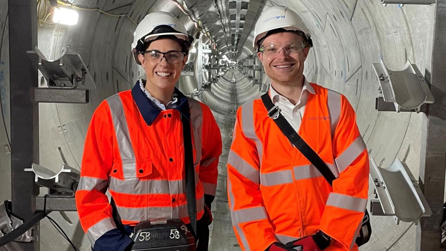 Minister in high viz clothing standing in a tunnel