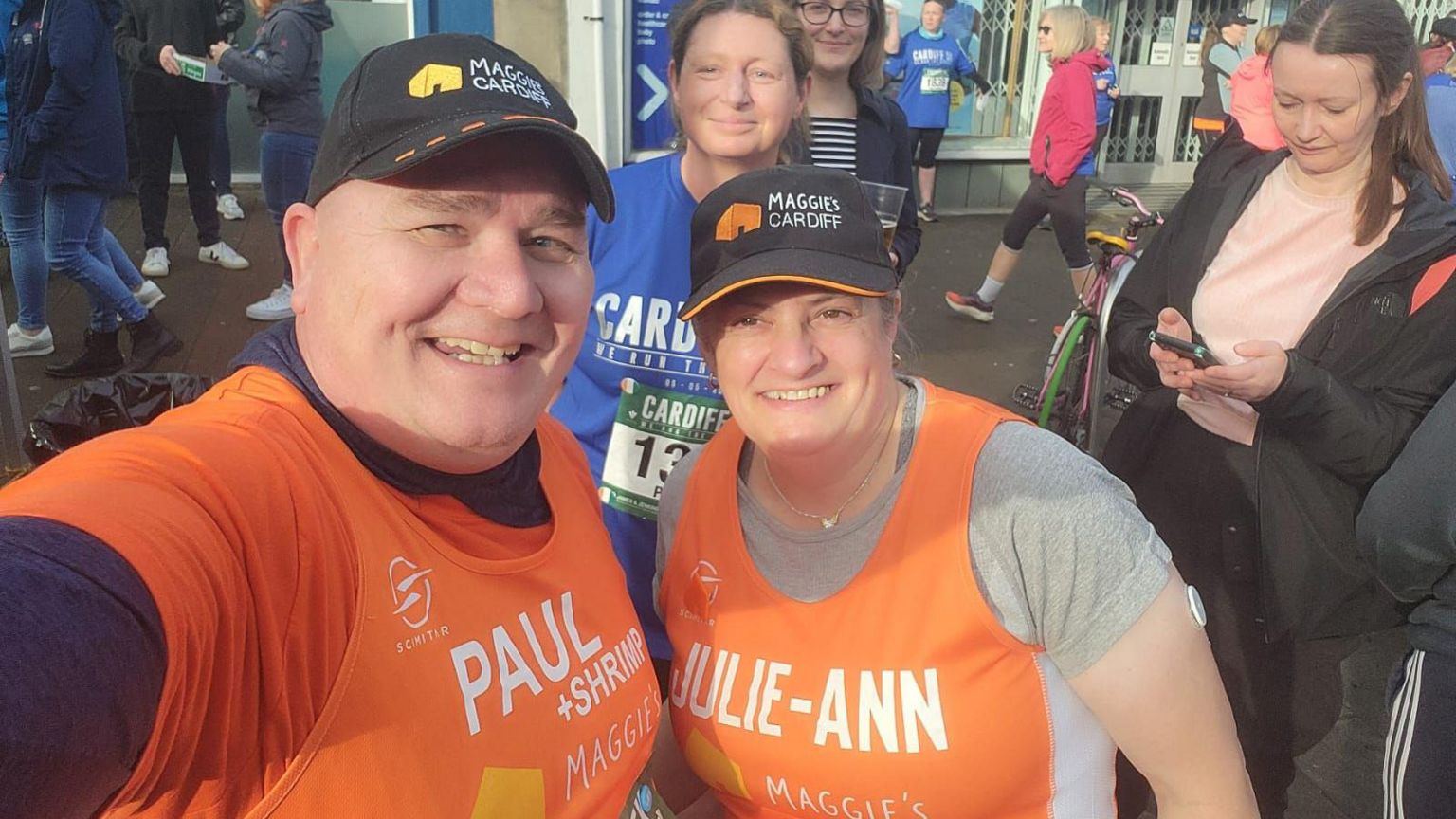 Paul and his friend Julie-Ann are taking a selfie before their race. They are both wearing their orange Maggie's racing bibs with their names on