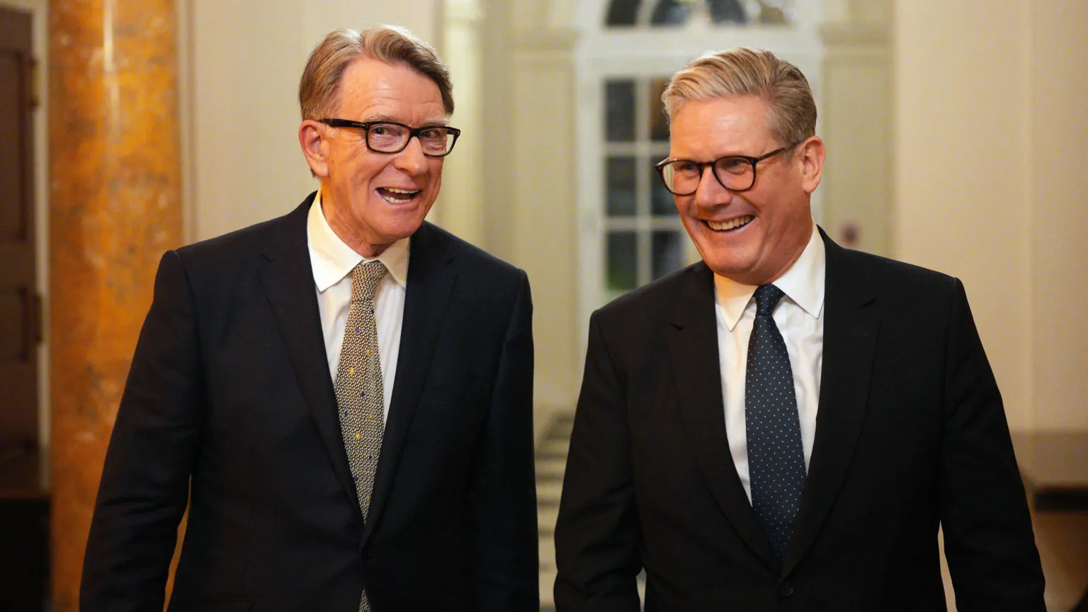 PA Media Lord Mandelson and Keir Starmer walking side by side and laughing