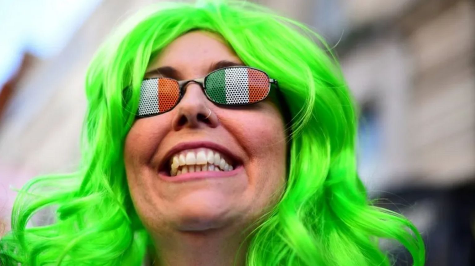 A man with Irish flag glasses and green hair