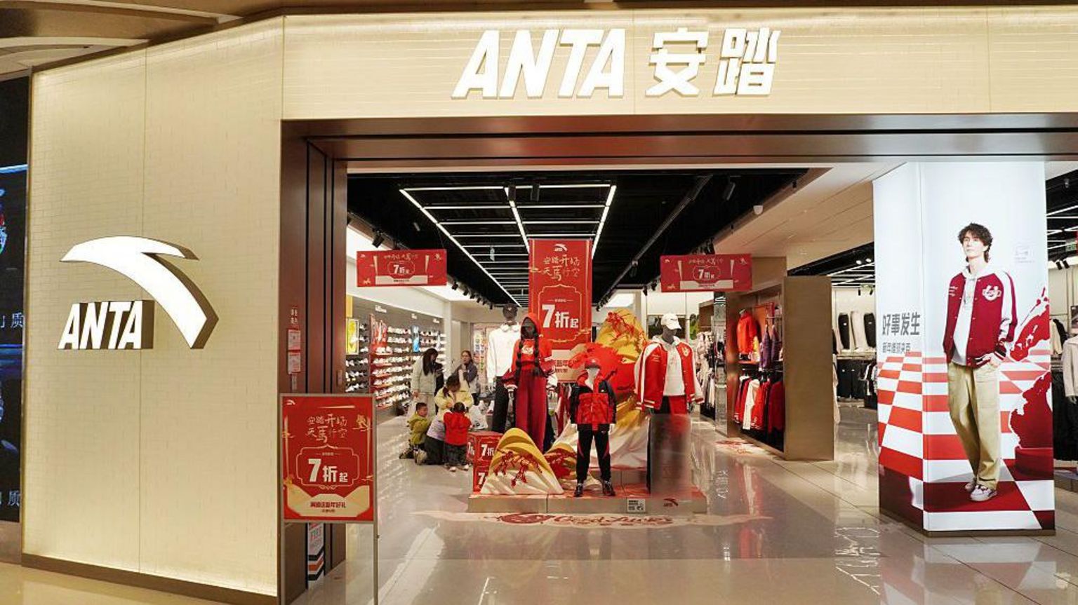 中国一家安踏门市的正门入口，门前悬挂多条红色横幅，宣传折扣优惠