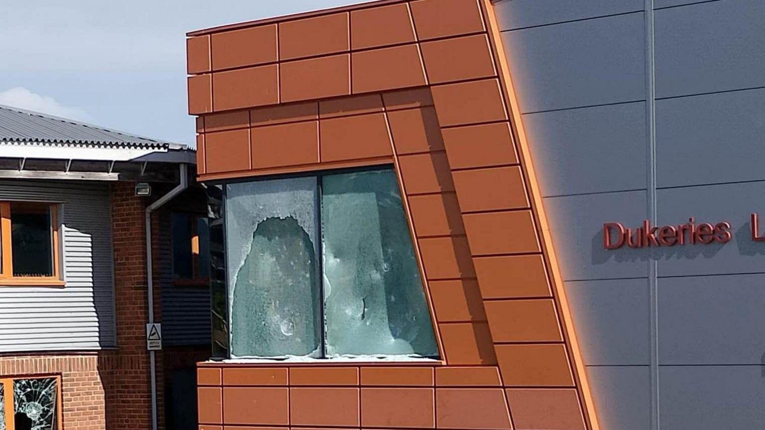 A medium close up of smashed windows on the corner of the Dukeries Leisure Centre