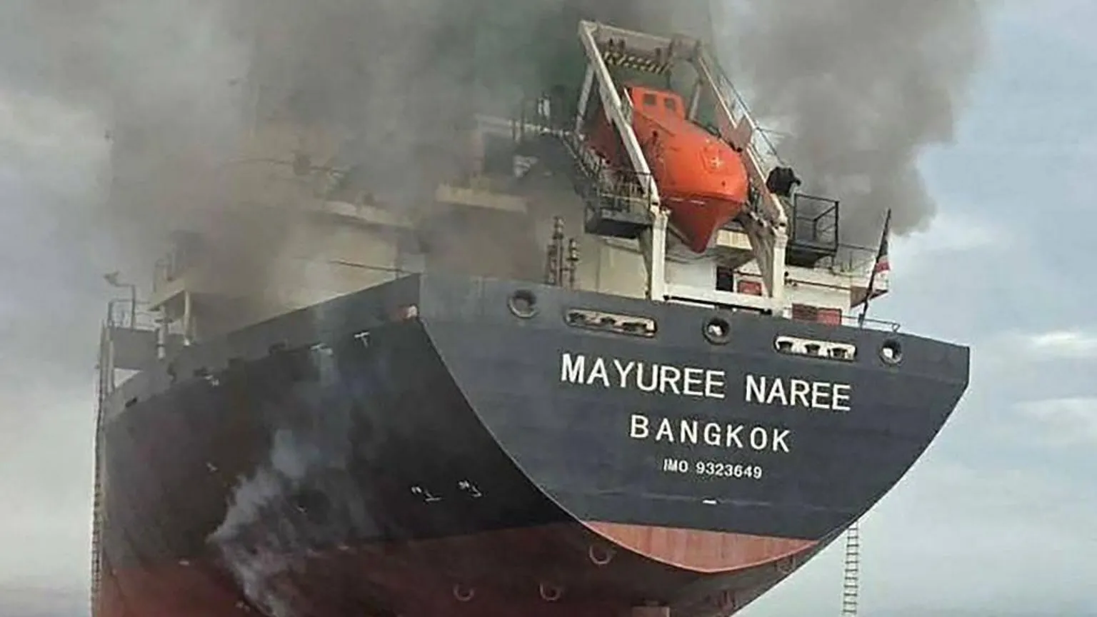 AFP A black cargo ship with the name "Mayuree Naree" and Bangkok painted on the side in white letters. Grey smoke is coming from the top of the ship.