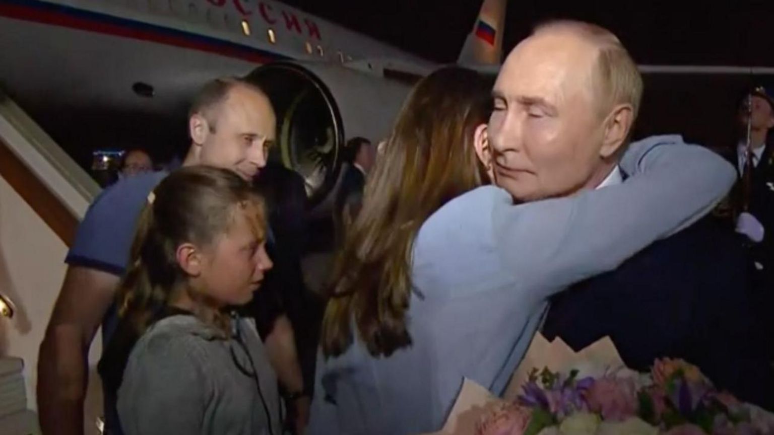 Russian President Vladimir Putin (R) welcomes prisoners released following the swap deal at Vnukovo International Airport in Moscow