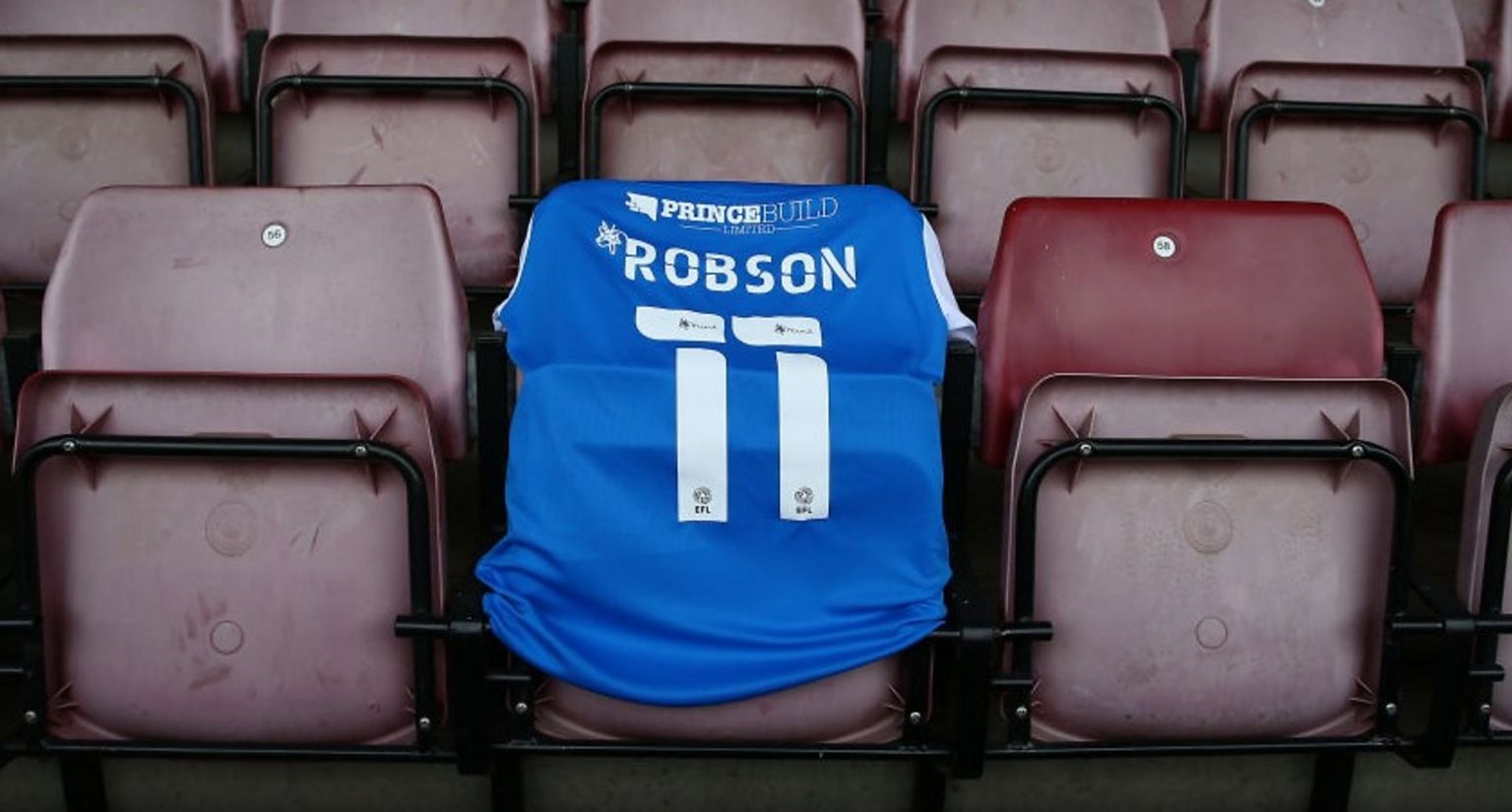 Blue Robson football shirt on stadium seats