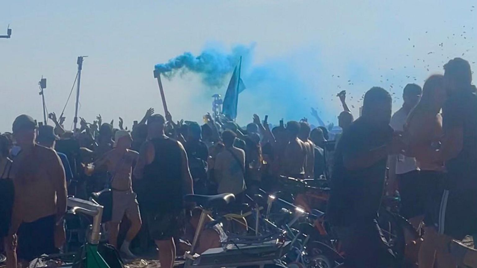 Large crowd of people dancing on Bournemouth beach.