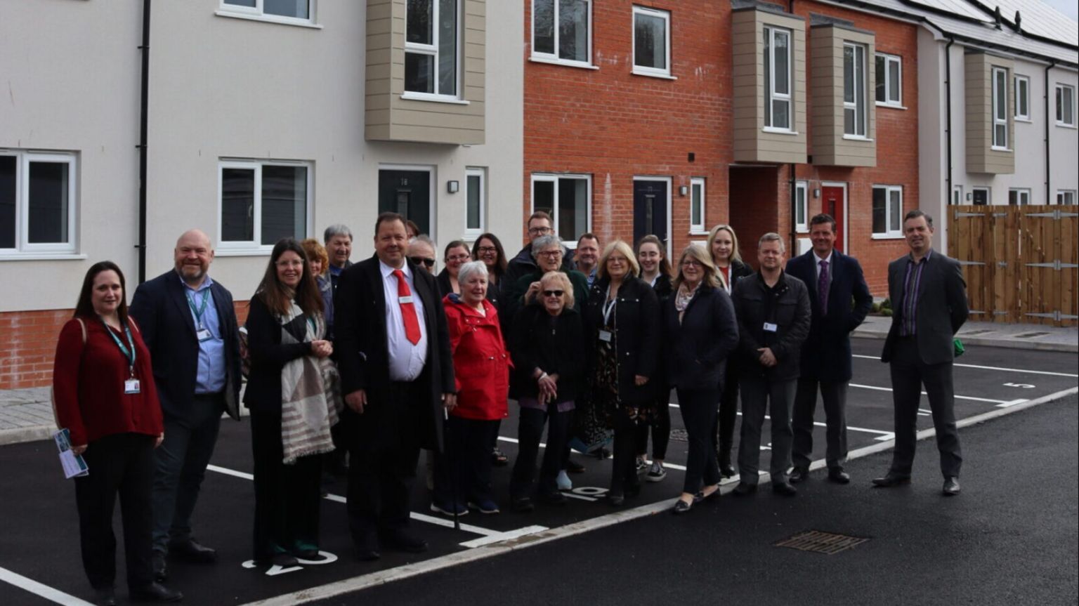 Bill Revans standing with a group of people outside new homes