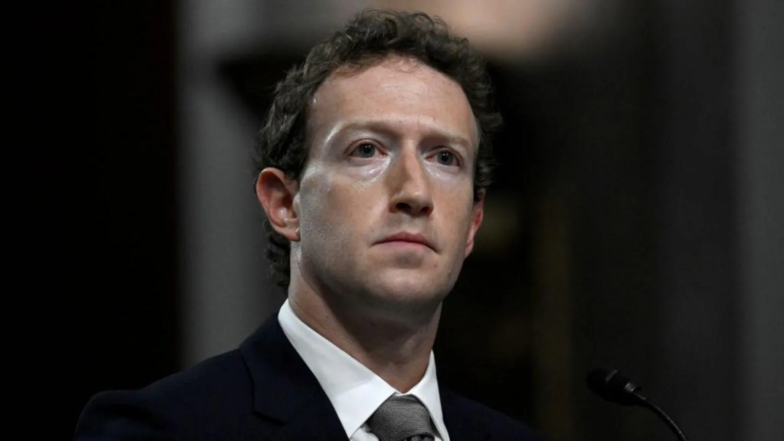 AFP via Getty Images Mark Zuckerberg, wearing a suit and grey tie, looks away from the camera with a grave expression as he is questioned by US lawmakers during a 2024 Senate hearing