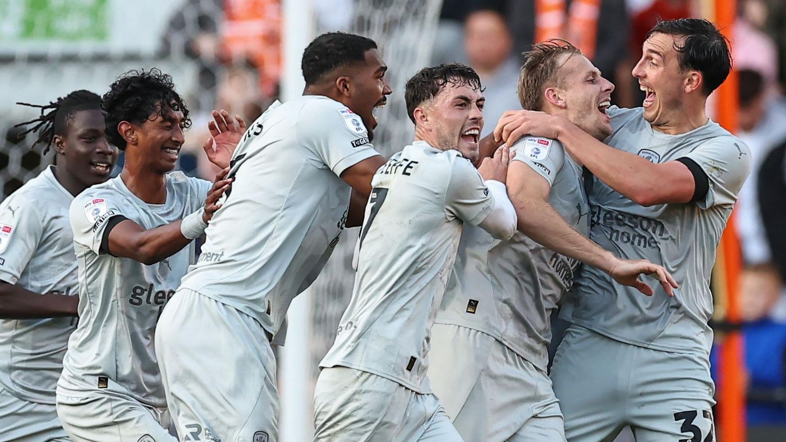 Marc Roberts is hugged by his Barnsley team-mates after heading a late winning goal in their league game at Blackpool