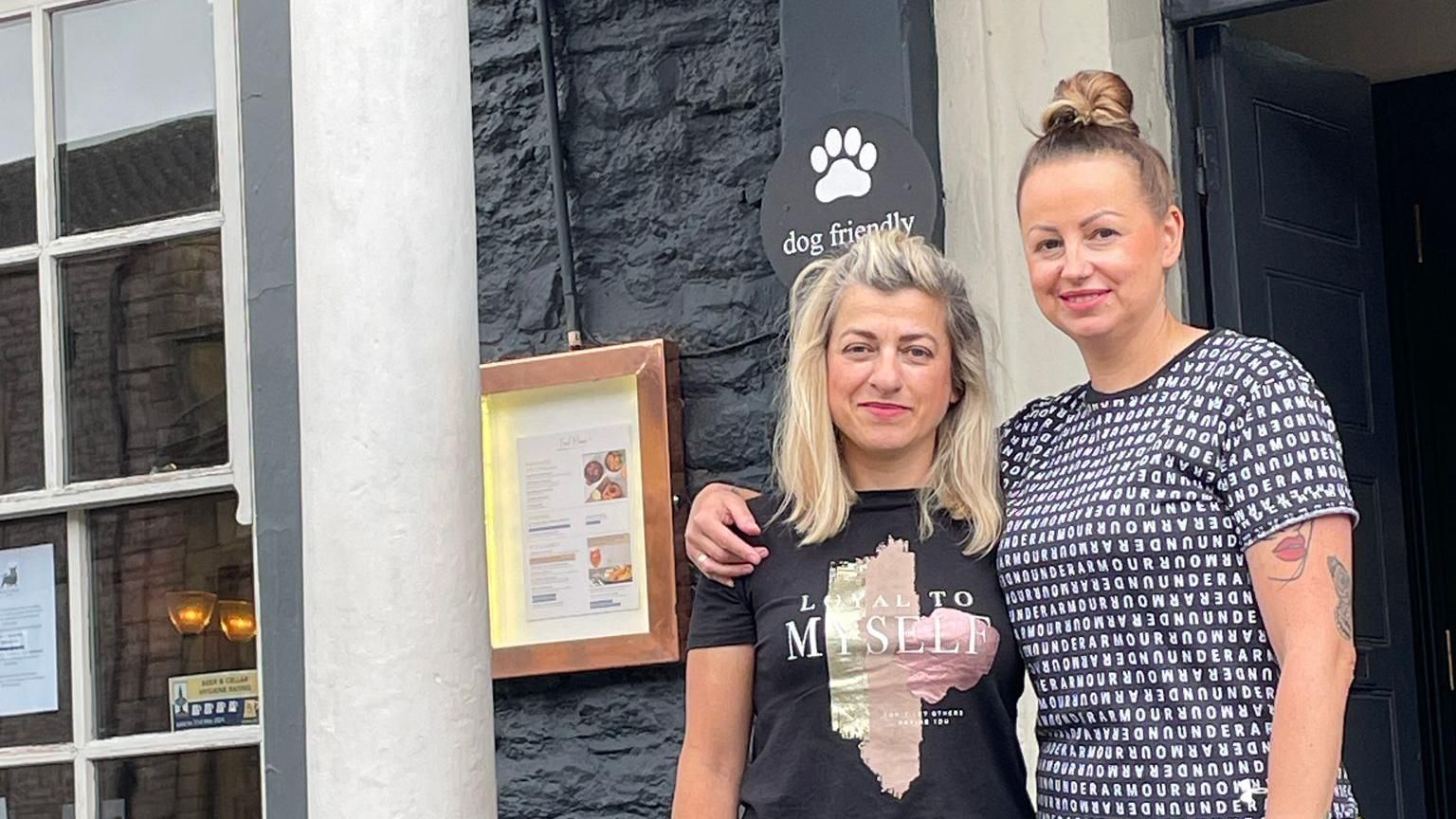 Two women stood in front of a pub