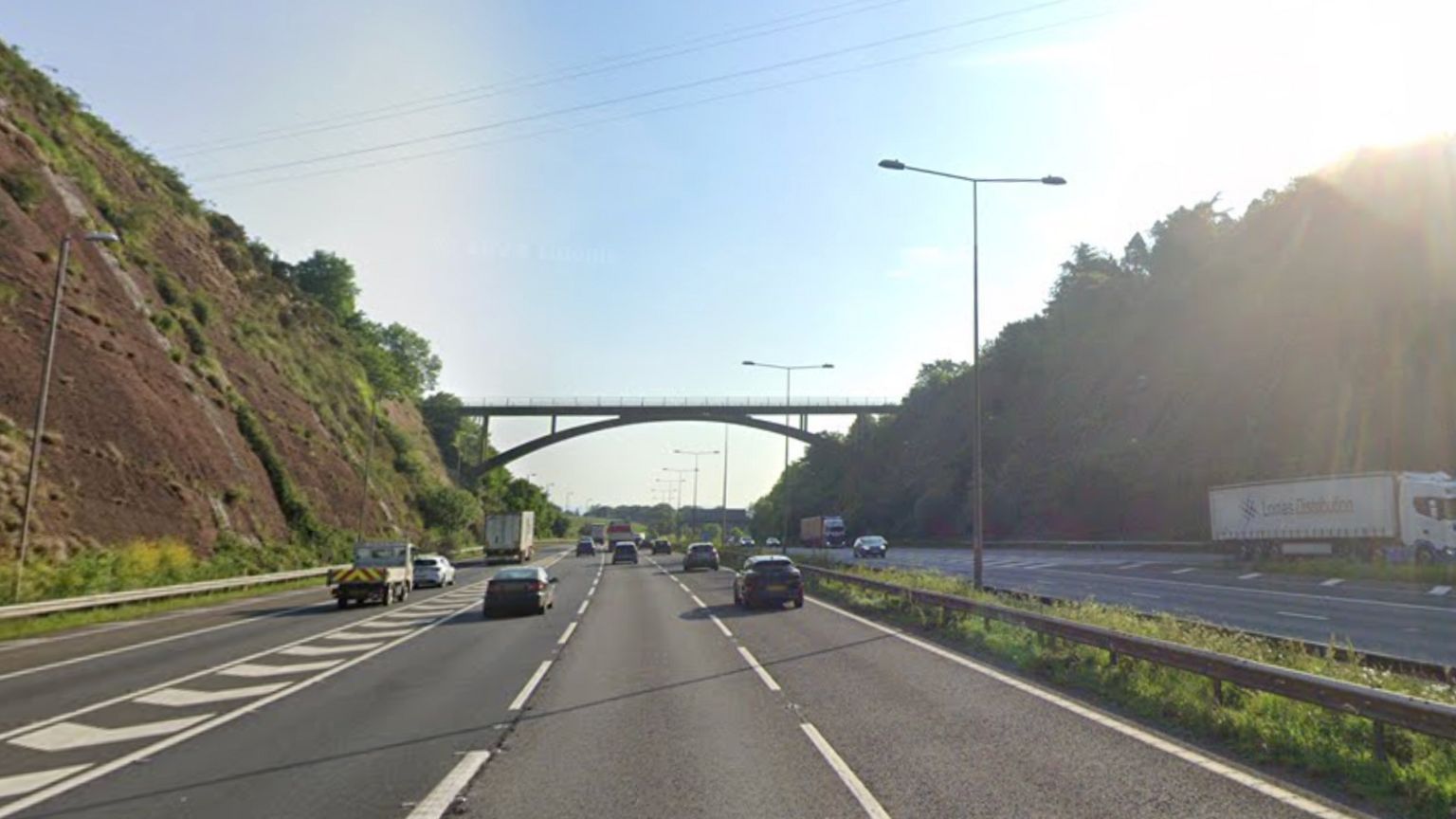 The M5 near junction 31 - there are three lanes with traffic joining via a lane on the left and there's a bridge over the motorway