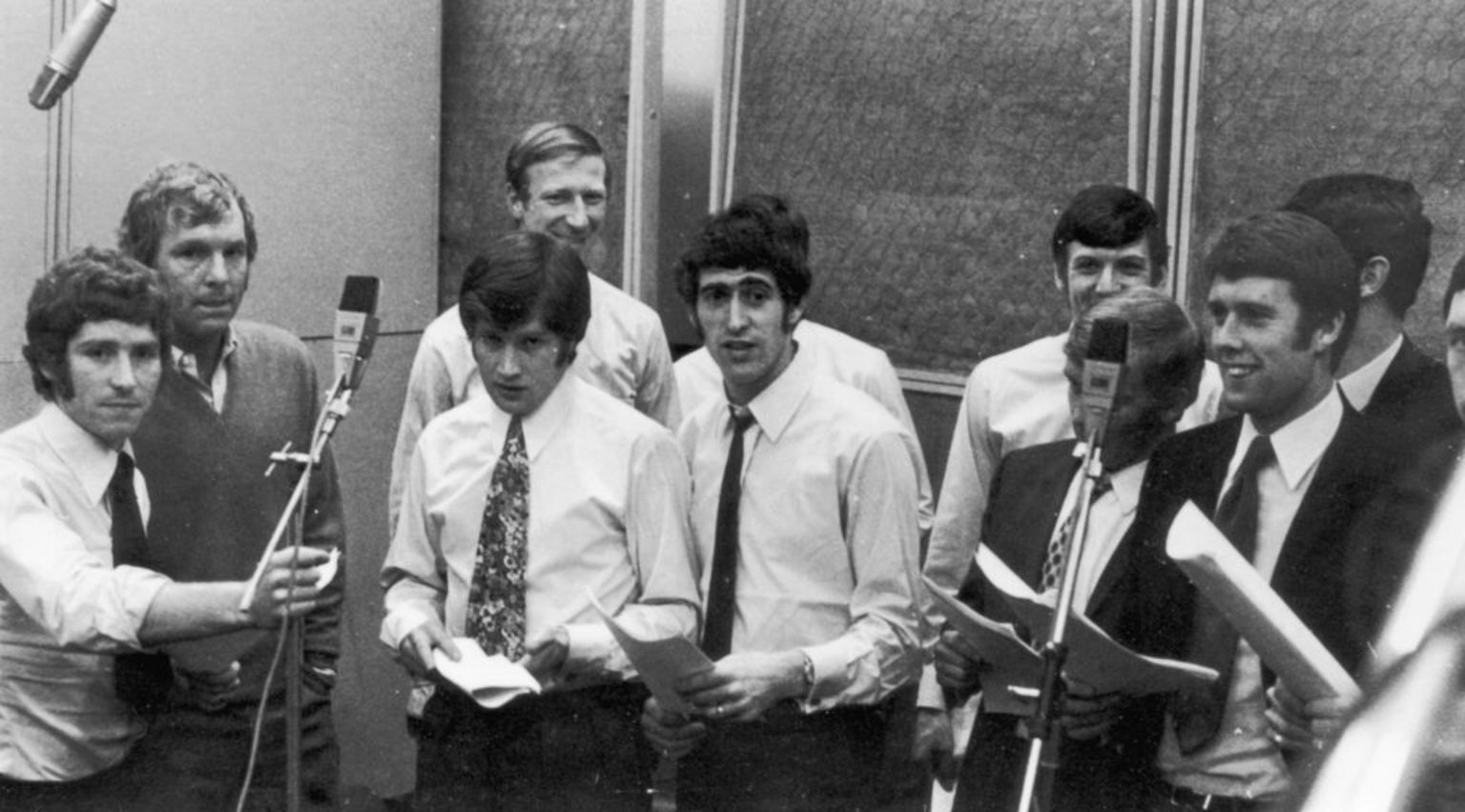 1970年世界杯前,英格兰世界杯代表队的黑白照片。他们身处录音室,面前有咪高峰,手上拿着写有歌词的纸张。